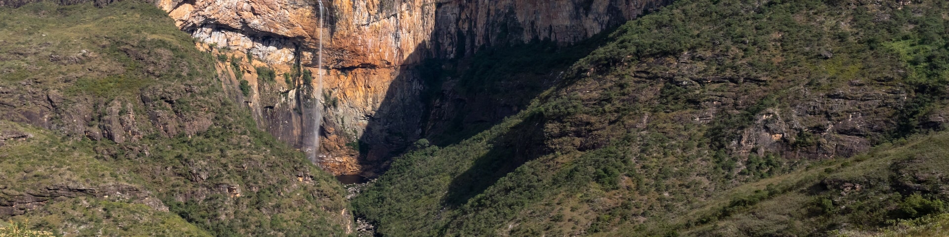 A canyon with steep cliffs and sparse vegetation.