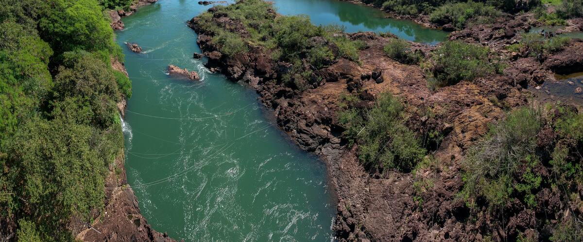 A river winding through a lush valley with dense greenery and rocky outcrops.