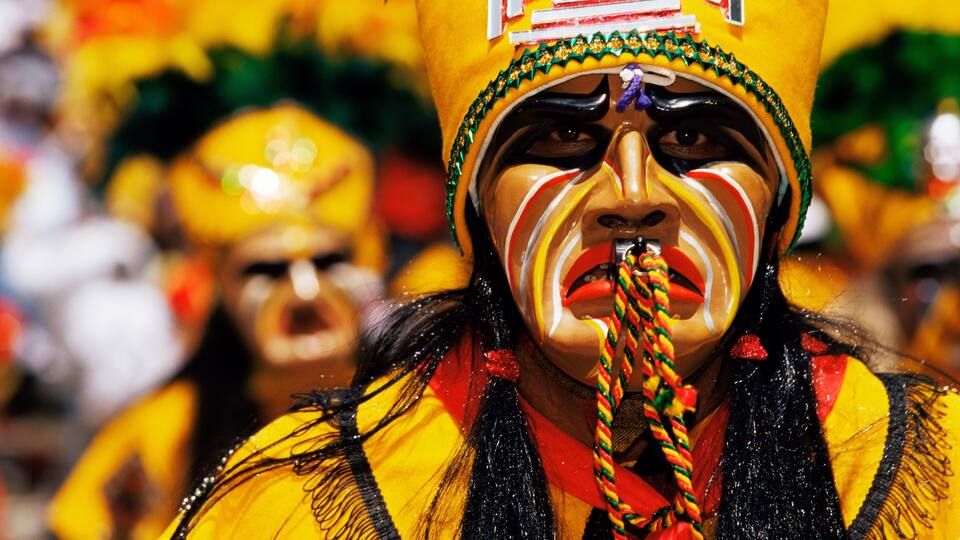 A person wearing a yellow and black costume with a headpiece.