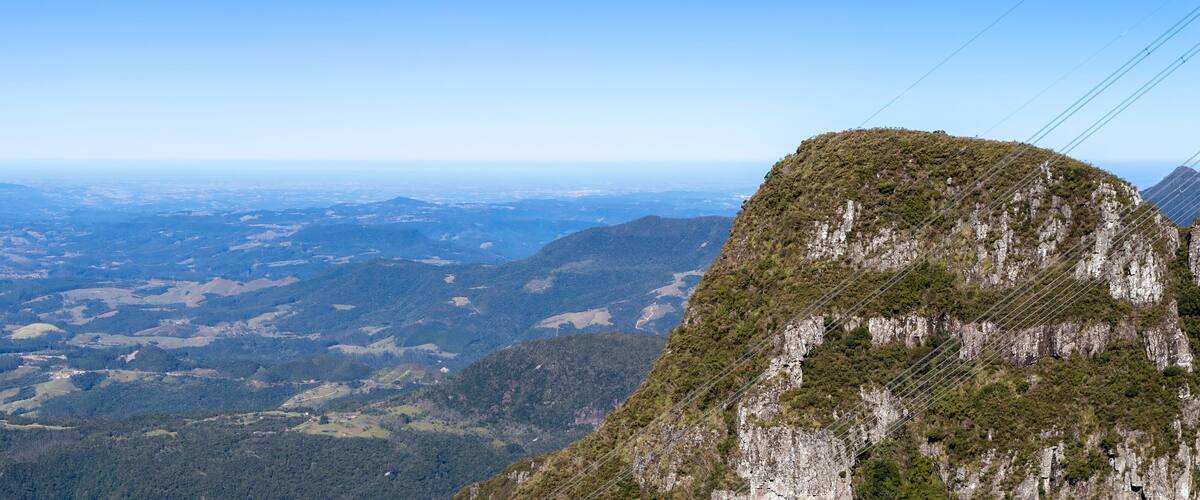 A mountainous landscape with a prominent rocky peak and a valley below.