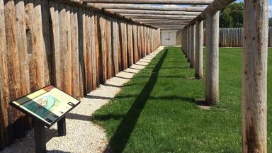A wooden pergola with a pathway leading through it.