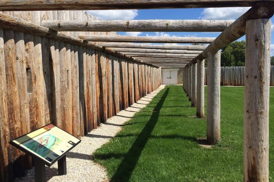 A wooden pergola with a pathway leading through it.