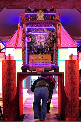 Worshipers crawling beneath the divine palanquin at the Chiayi Lantern Festival, Taiwan.