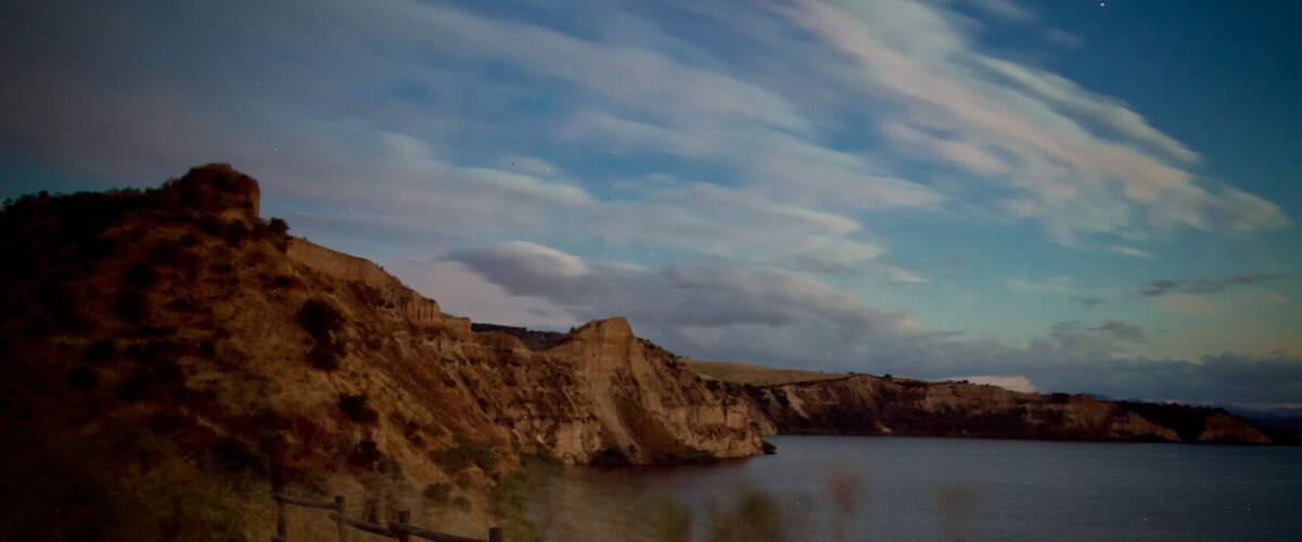 A coastal landscape with cliffs and a calm body of water.