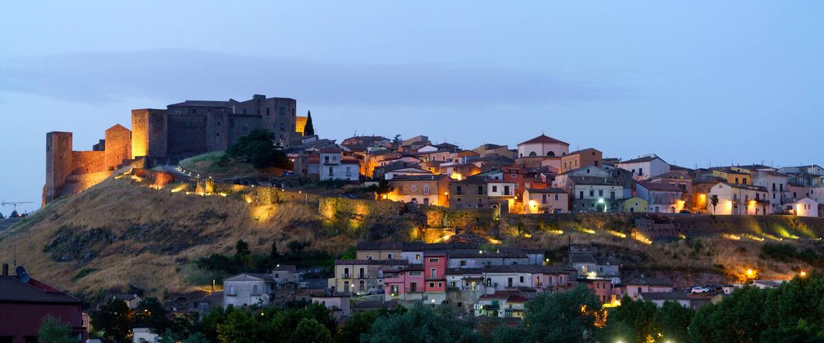 A historic hilltop town with a prominent castle and colorful buildings.
