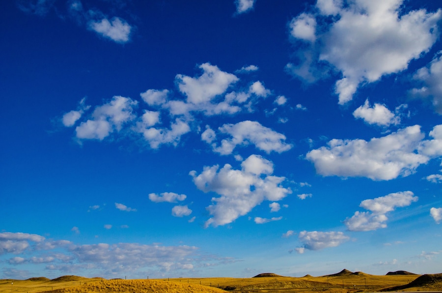USA, Wyoming, Moorcroft Devil's Tower National Monument, clear blue sky with puffy white clouds, Golden Hills