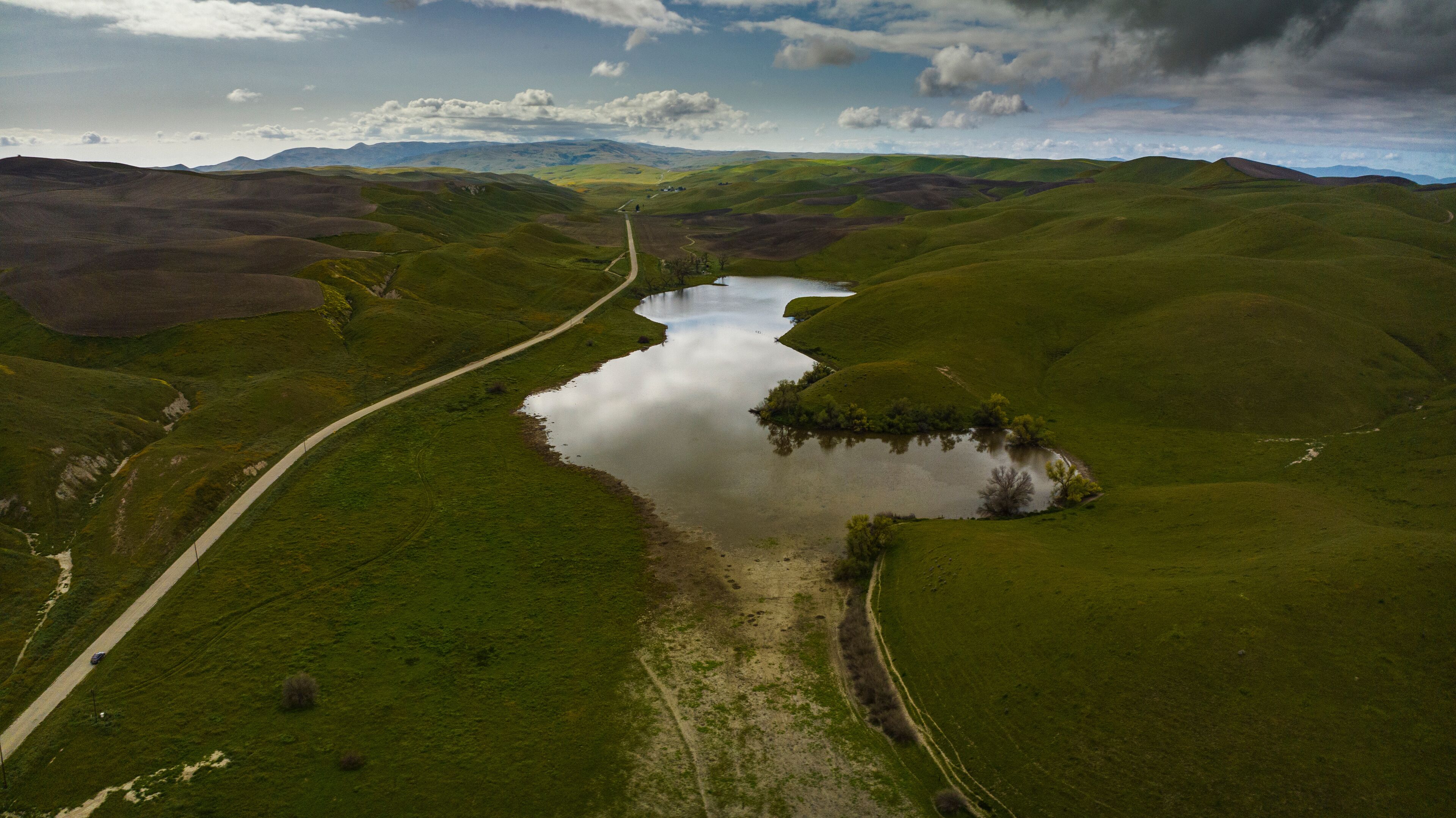 APRIL 2023, SHANDON, CA. - rolling green spring hills and pond in the County of San Luis Obisbo, California at sunrise with morning fog