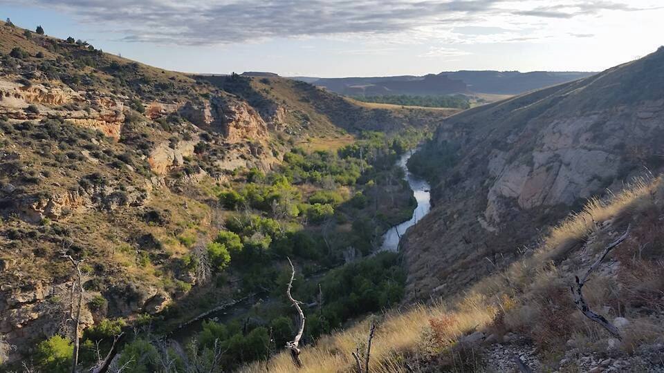 A river valley with steep, rocky hills and sparse vegetation.
