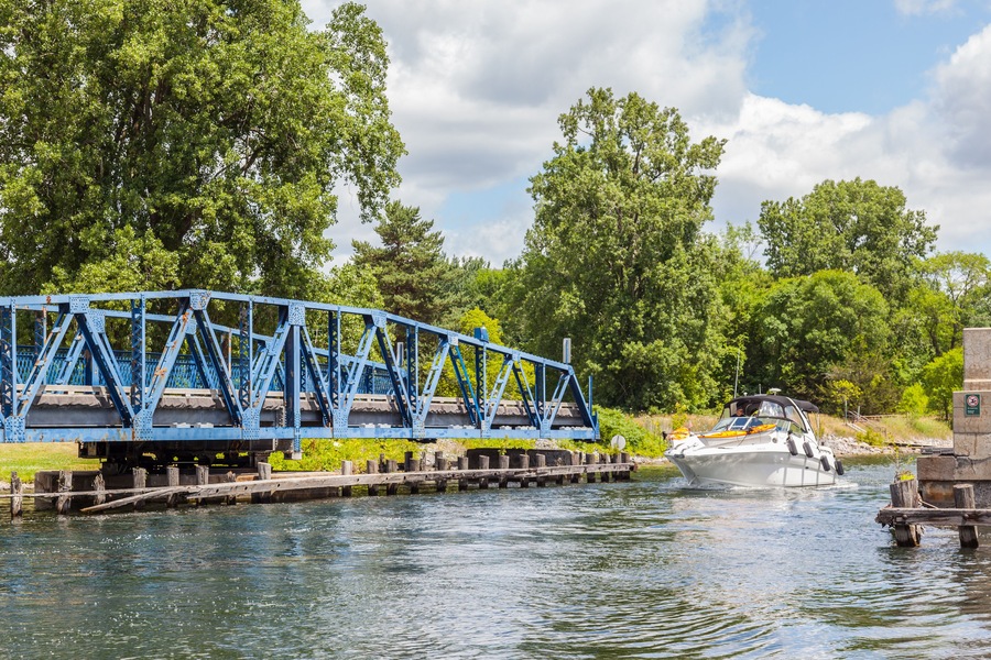 QUINTE WEST, ONTARIO, CANADA - July 10, 2016: Boat passing opened swing bridge on Murray Canal, Quinte West, Ontario.
The Murray Canal was built between 1882 and 1889.