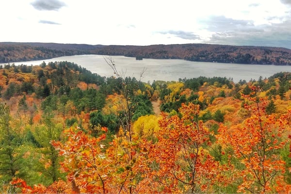 Un lac entouré d’un paysage aux couleurs automnales.