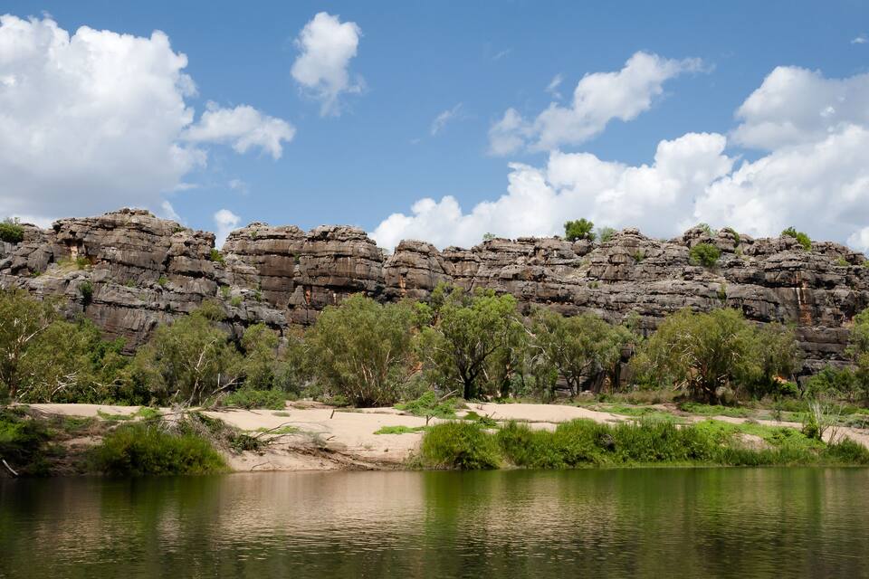 A river with rocky cliffs in the background.