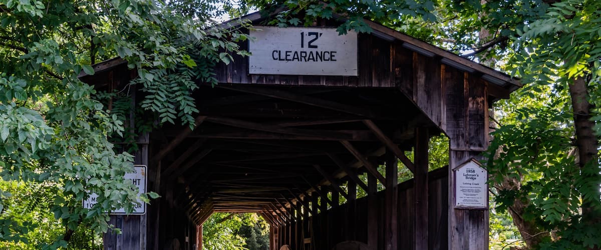 A wooden covered bridge with a 12' clearance sign.