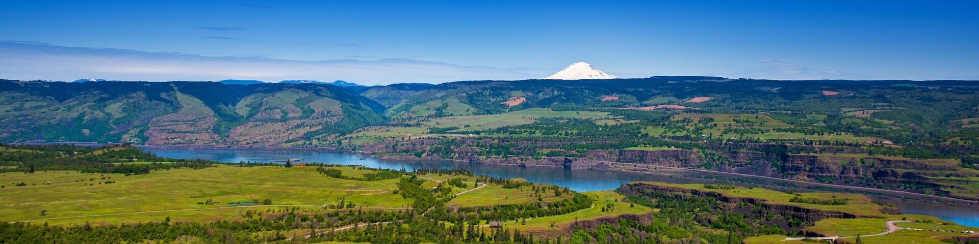 A mountainous landscape with a lake and a prominent snow-capped peak.