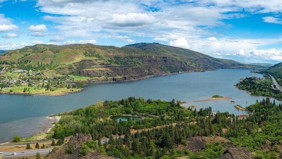 Looking east from Rowena Crest at the Columbia River, Interstate Highway 80N, and a freight train loaded with containers, Oregon, and city of Lyle Washington