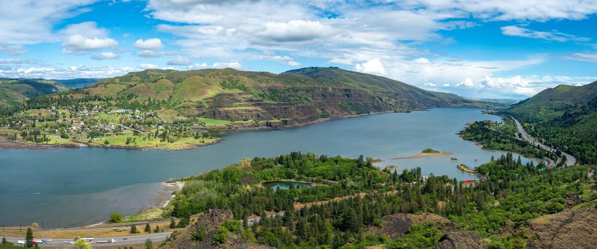 A lake surrounded by hills, a small town, and a winding road.