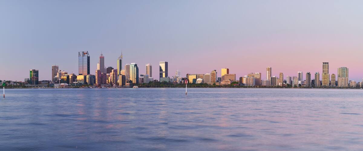 Panoramic view of the Perth skyline across the Swan River at dusk.