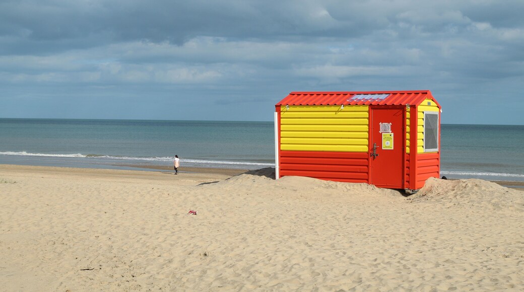 Orange and yellow lifeguard hut on Brittas Bay beach, County Wicklow, Ireland with overcast sky backdrop