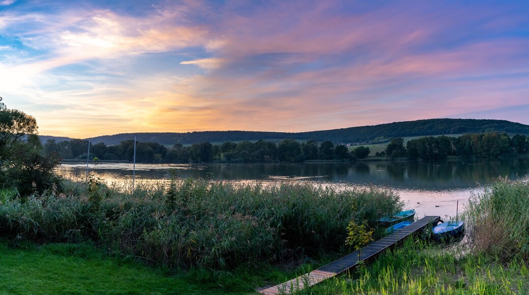 colorful sunset over lake landscape with small rowboats