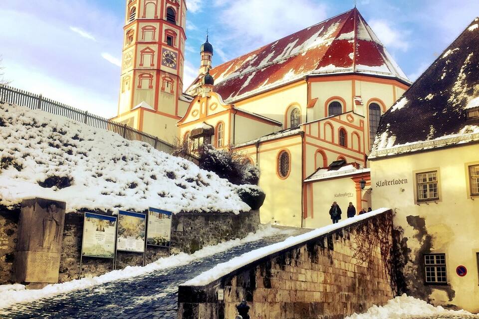 Um edifício histórico com uma torre de relógio e uma igreja com telhado vermelho.