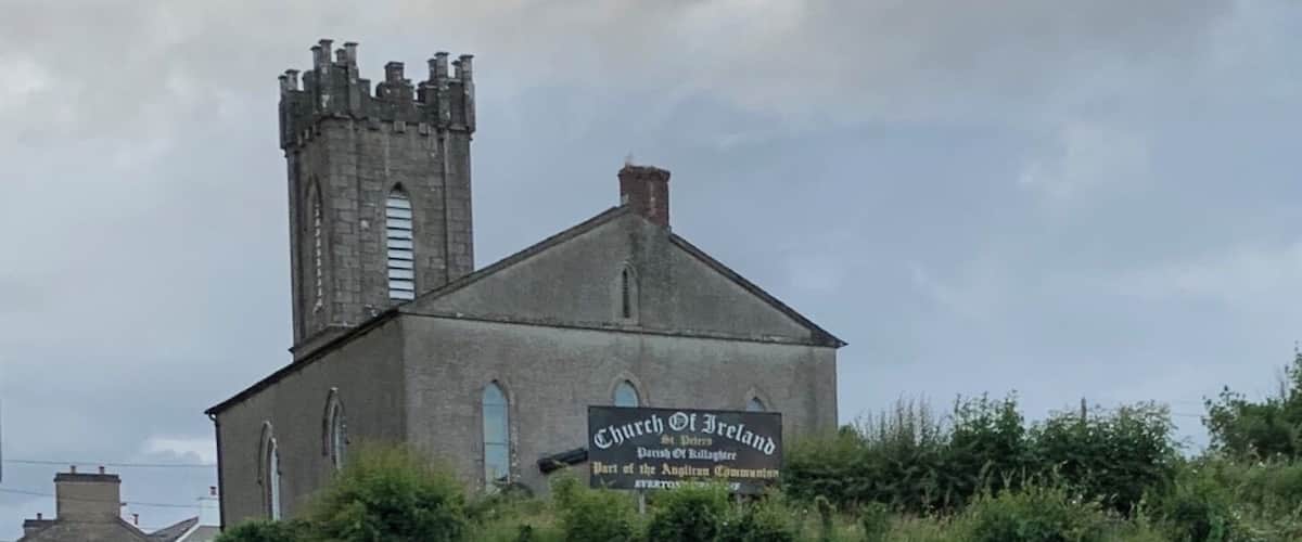 A church with a tall tower and a sign reading "Church of Ireland".