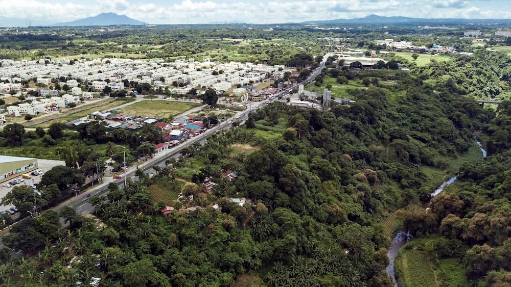 Aerial of Emilio Aguinaldo Highway and a nearby river in Dasmarinas Cavite. View of road that goes straight to Tagaytay