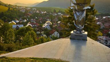 Uma estátua no alto de uma colina, com vista para uma aldeia.