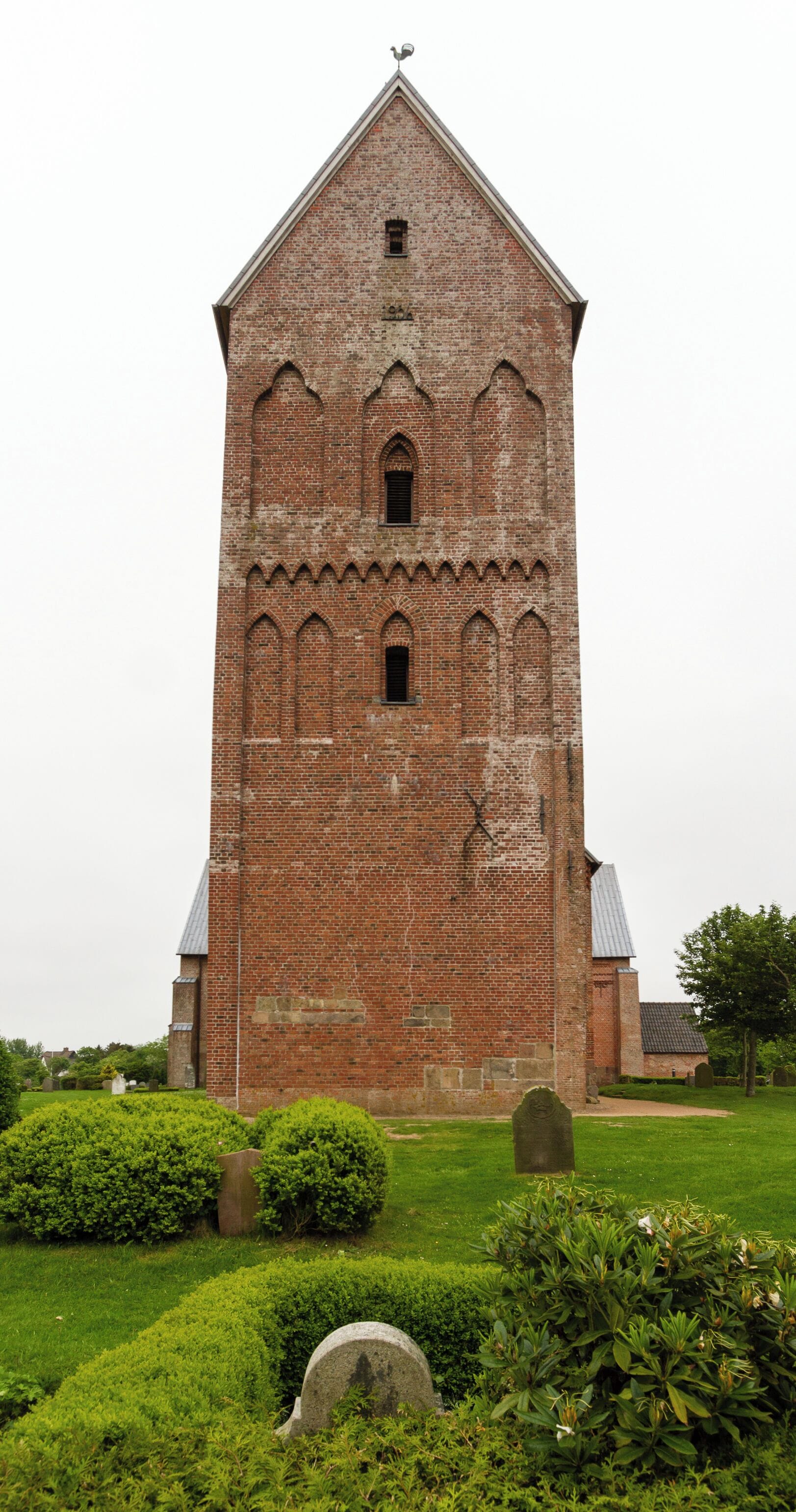 A tall brick church with arched windows and a pointed roof.