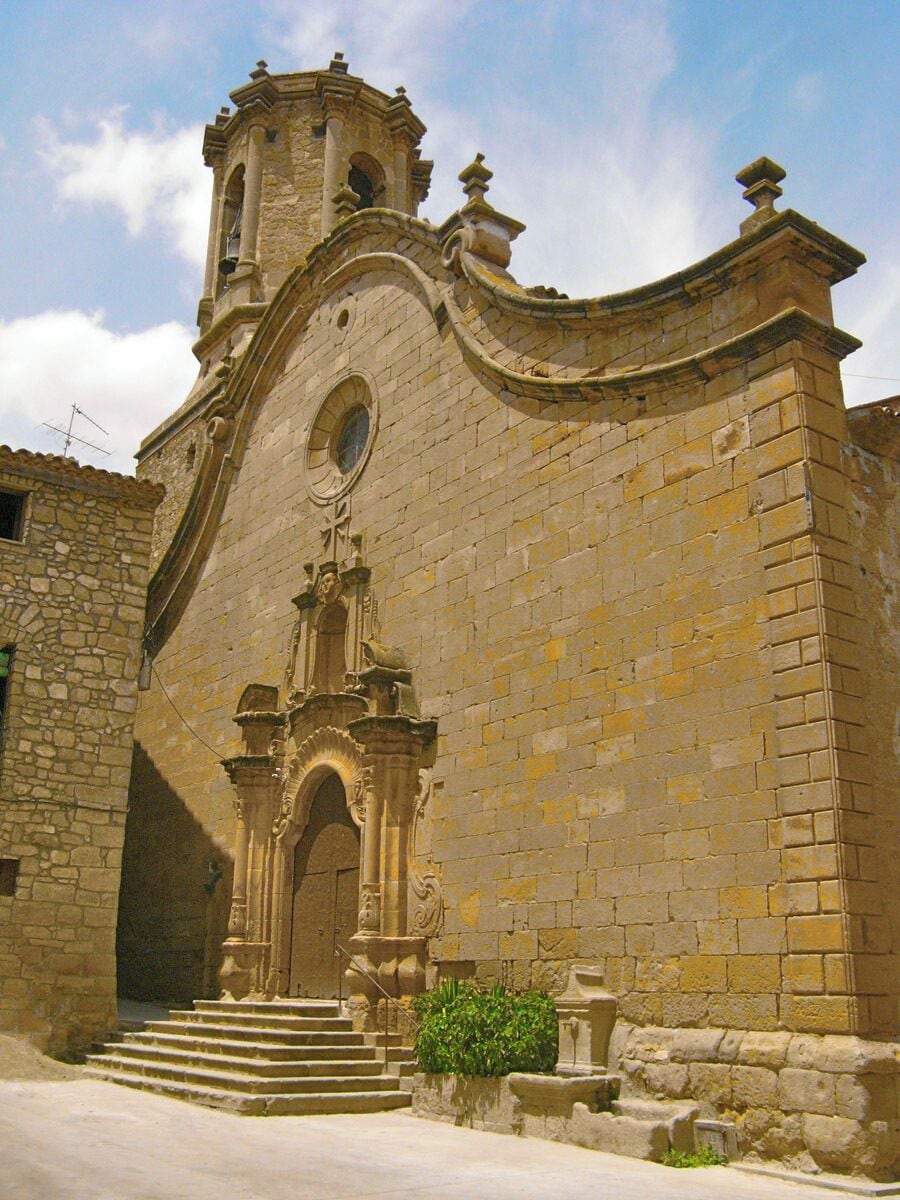 A historic stone church with a bell tower and arched entrance.