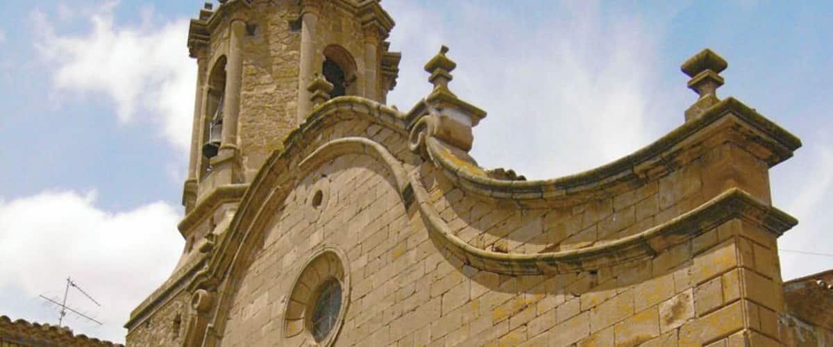 A historic stone church with a bell tower and arched entrance.