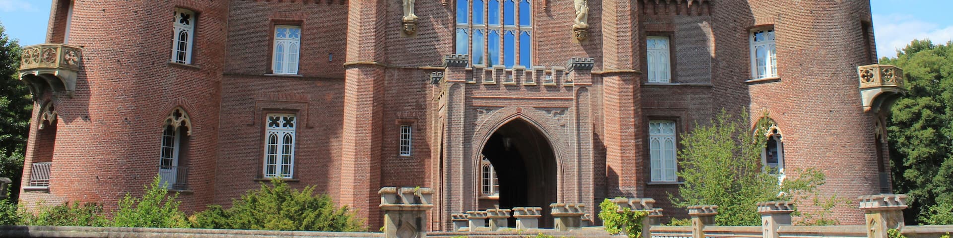 A large, historic castle with two prominent towers, arched windows, and a central entrance.