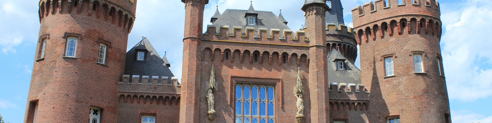 Un castillo grande e histórico, con dos torres destacadas, ventanas de arco y una entrada central.