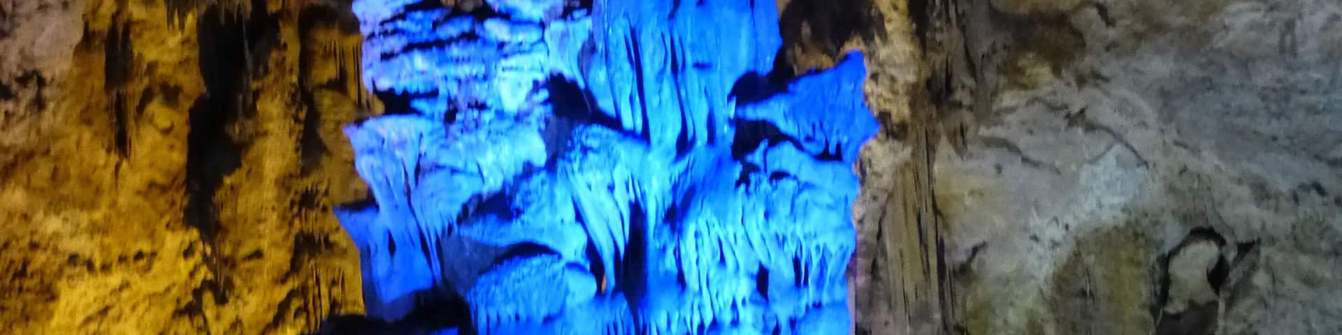 A cave with blue illuminated stalactites.