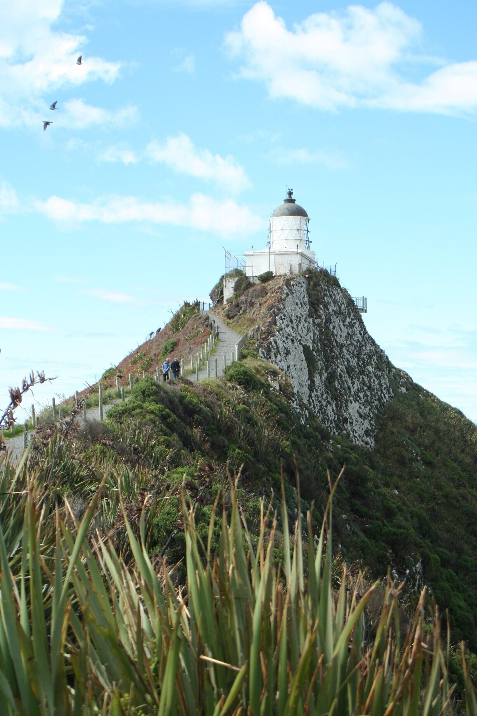 A lighthouse on a hill with a clear sky.