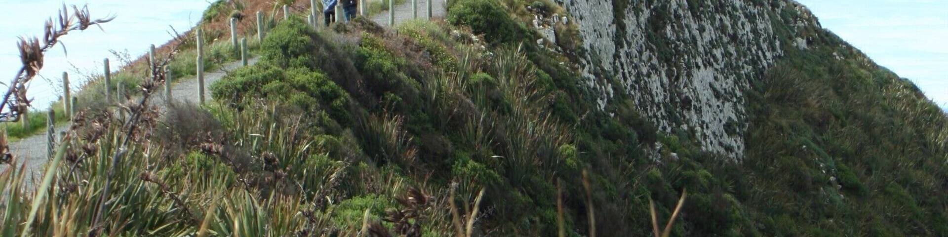 A lighthouse on a hill with a clear sky.