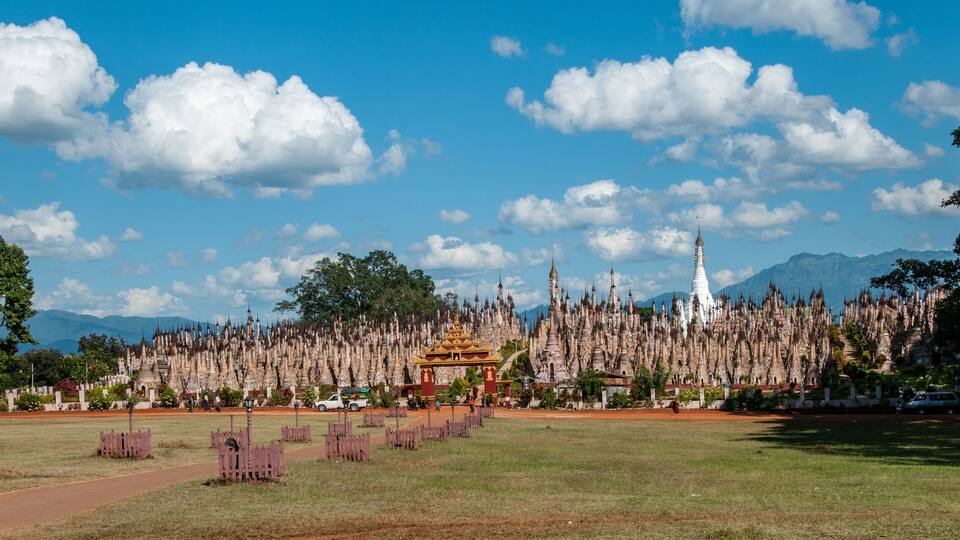 A temple complex with numerous spires and a prominent golden stupa.