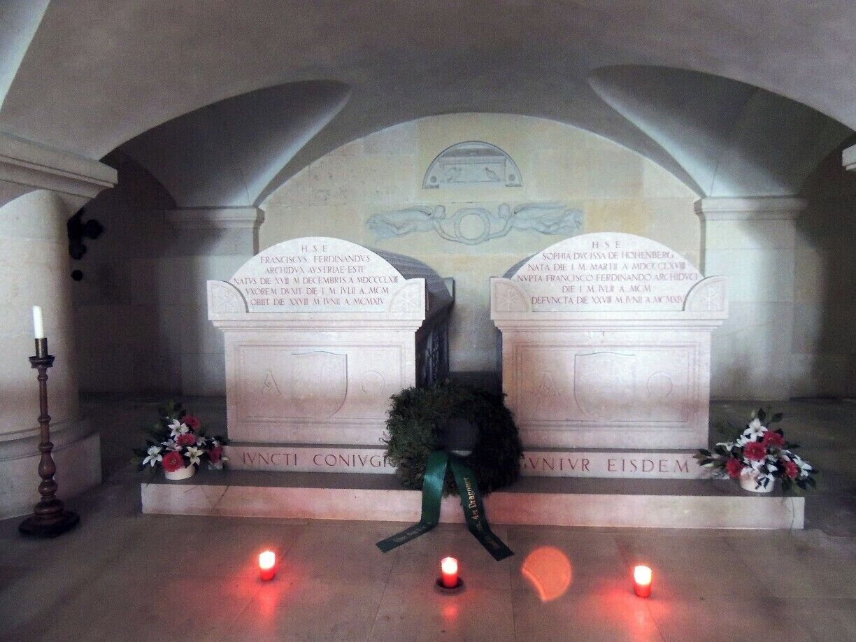 A memorial with two tombstones, each with Latin inscriptions, under an arched ceiling.