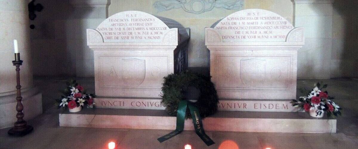 A memorial with two tombstones, each with Latin inscriptions, under an arched ceiling.