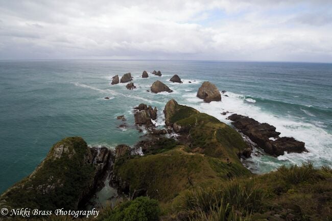 A coastal landscape with rocky outcrops and the ocean.