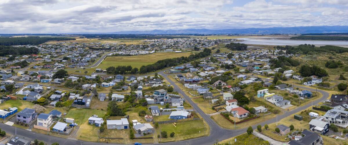 A residential area with houses, roads, and a river.