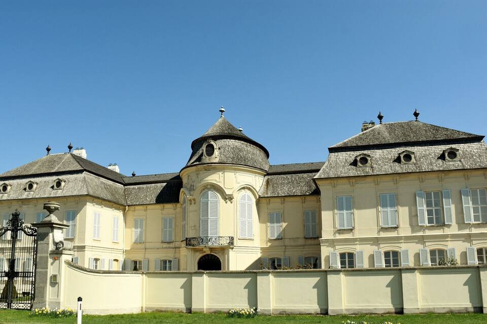 Ein großes, historisches Gebäude mit einer zentralen Kuppel, mehreren Schornsteinen und einem Eingangstor.