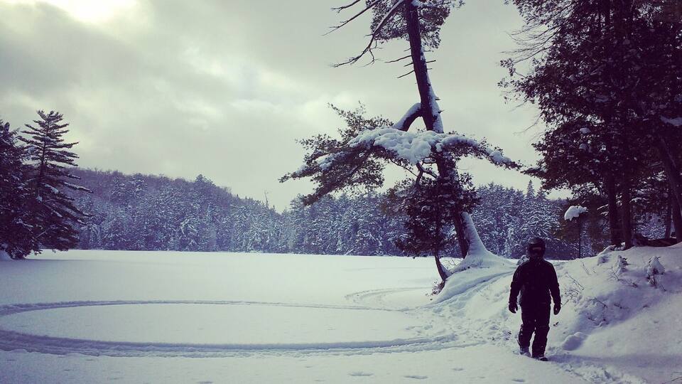 A snowy landscape with a person walking on a trail.