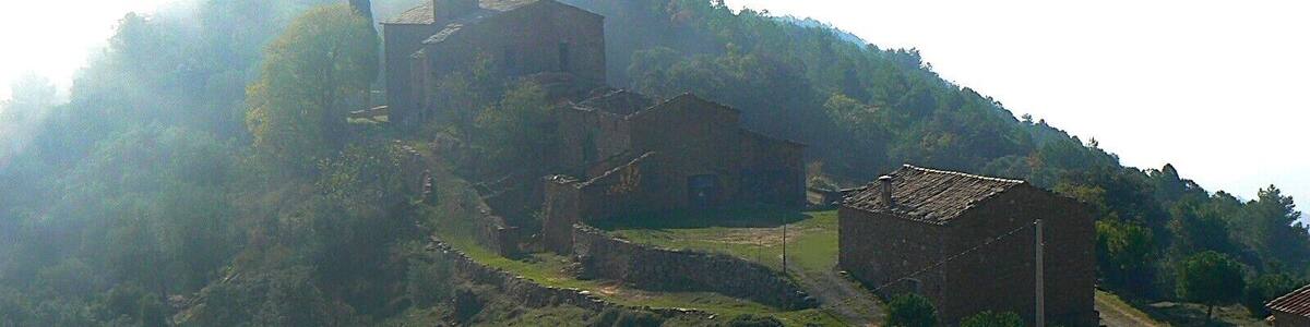 Poble de Pallerols de Rialb (La Baronia de Rialb, Catalunya). A primer pla l'antiga escola, seguit de la rectoria i l'església de Sant Esteve (del Romànic del s. XI)