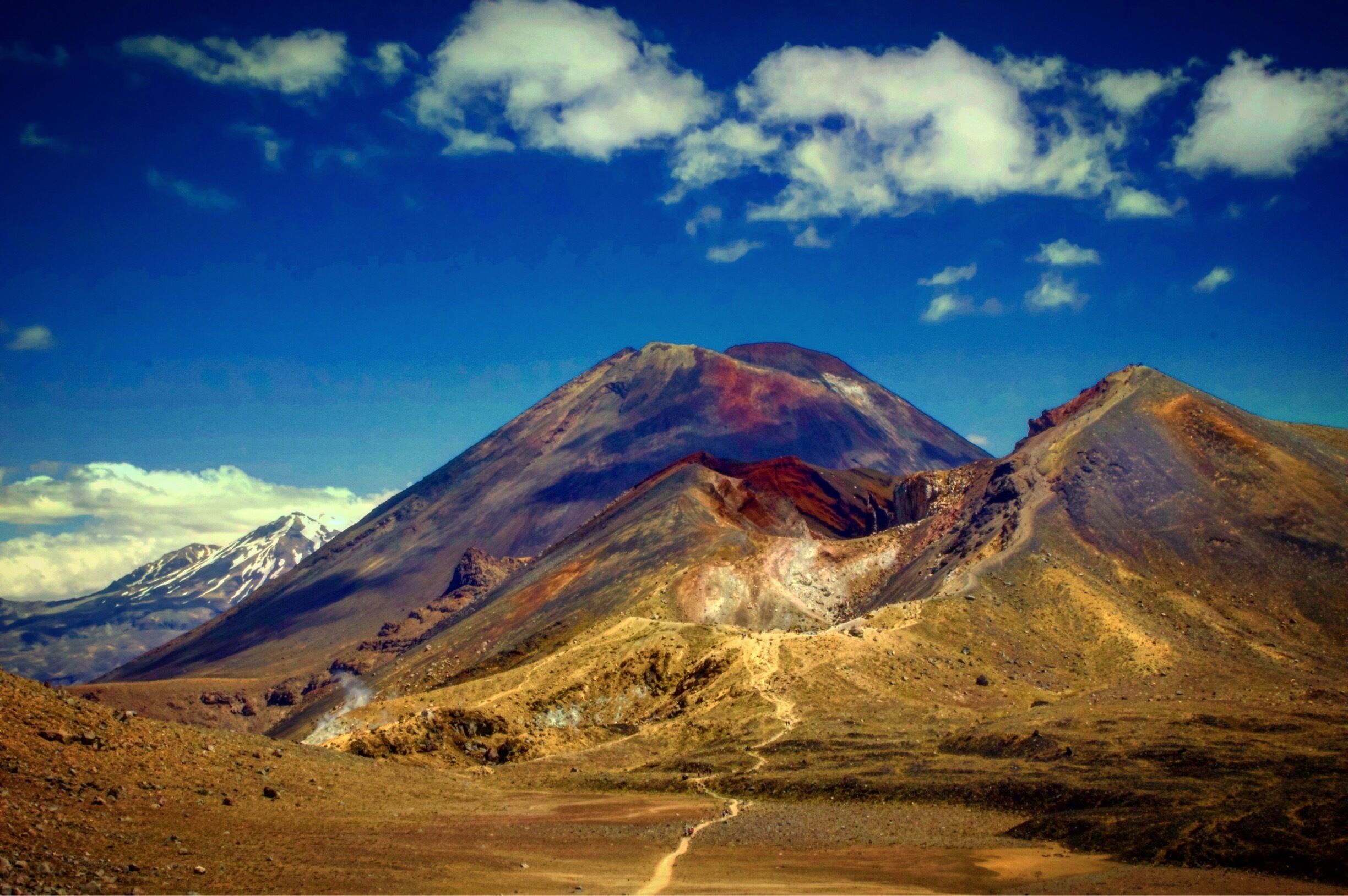 A mountain range with a prominent peak and a snow-capped mountain in the background.