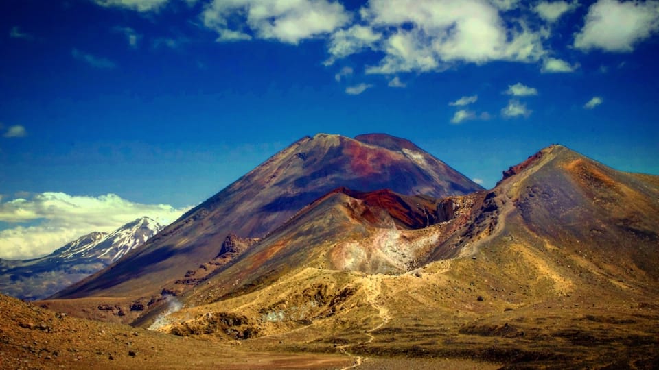 A mountain range with a prominent peak and a snow-capped mountain in the background.