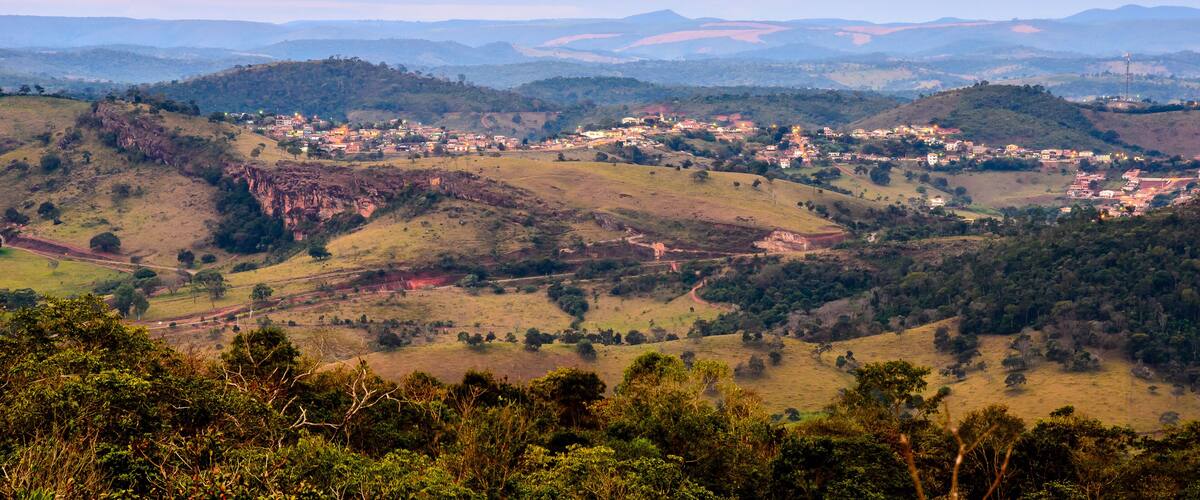 A valley with a small town nestled among rolling hills and mountains.