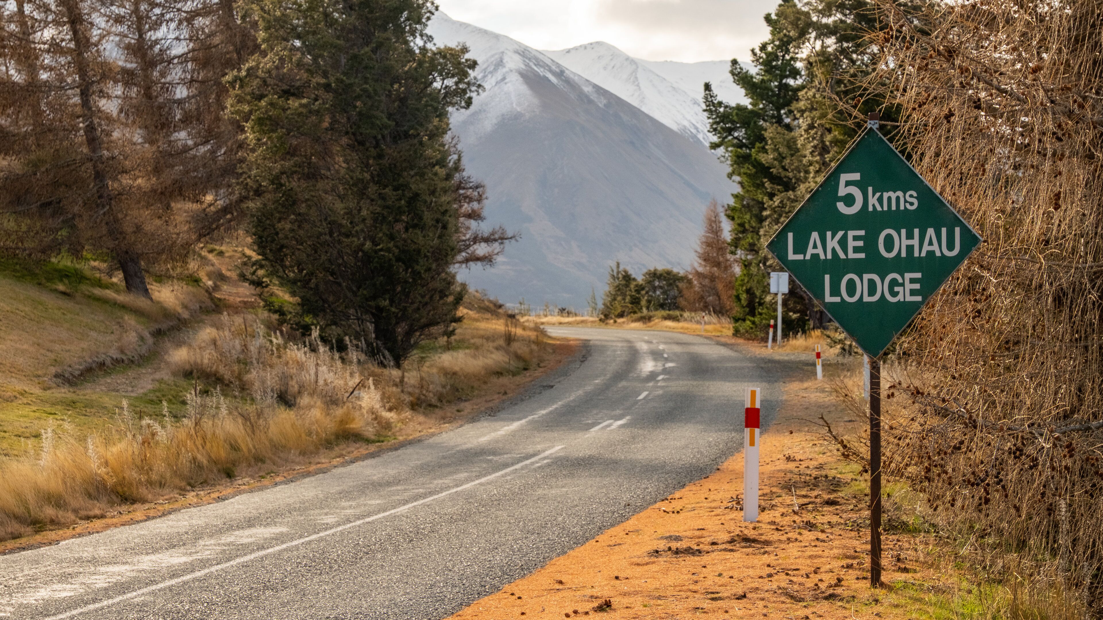 A road leading to Lake Ohau Lodge, with a sign indicating a 5 km distance.