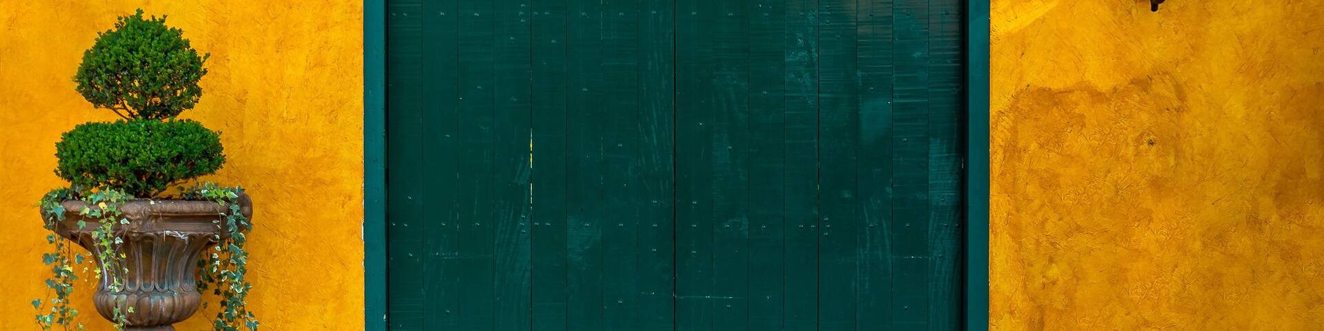 Green wooden door on a yellow textured colonial wall historic center of Embu das Artes Sao Paulo
