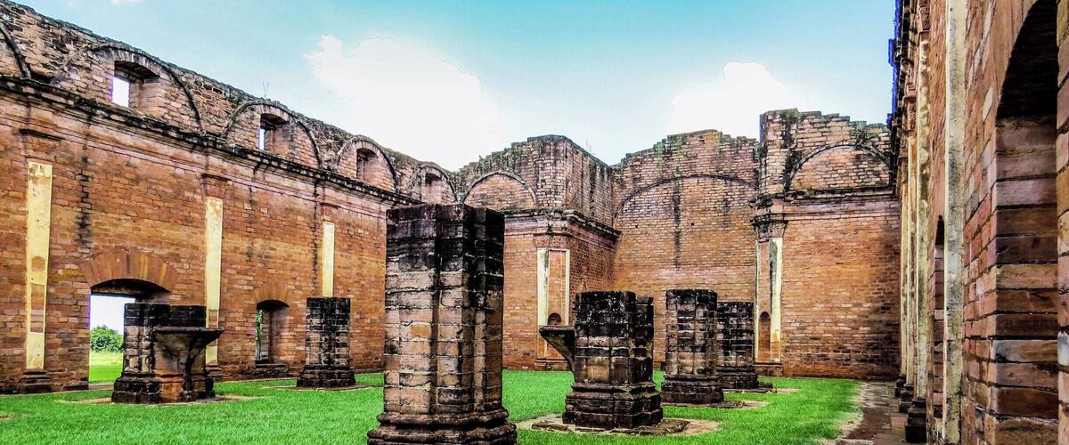 A courtyard with ancient brick walls and stone columns.