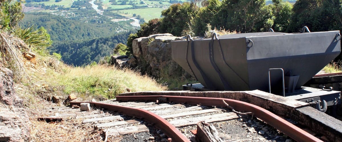 A railway track with a large concrete structure and a scenic view of a coastal landscape.