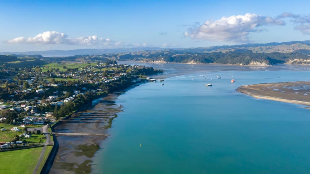 Aerial view of Kawhia Harbour, Kawhia, Waikato, New Zealand, showcasing the town's coastal location. The image highlights the natural beauty of the area, with its waterways and landscape.